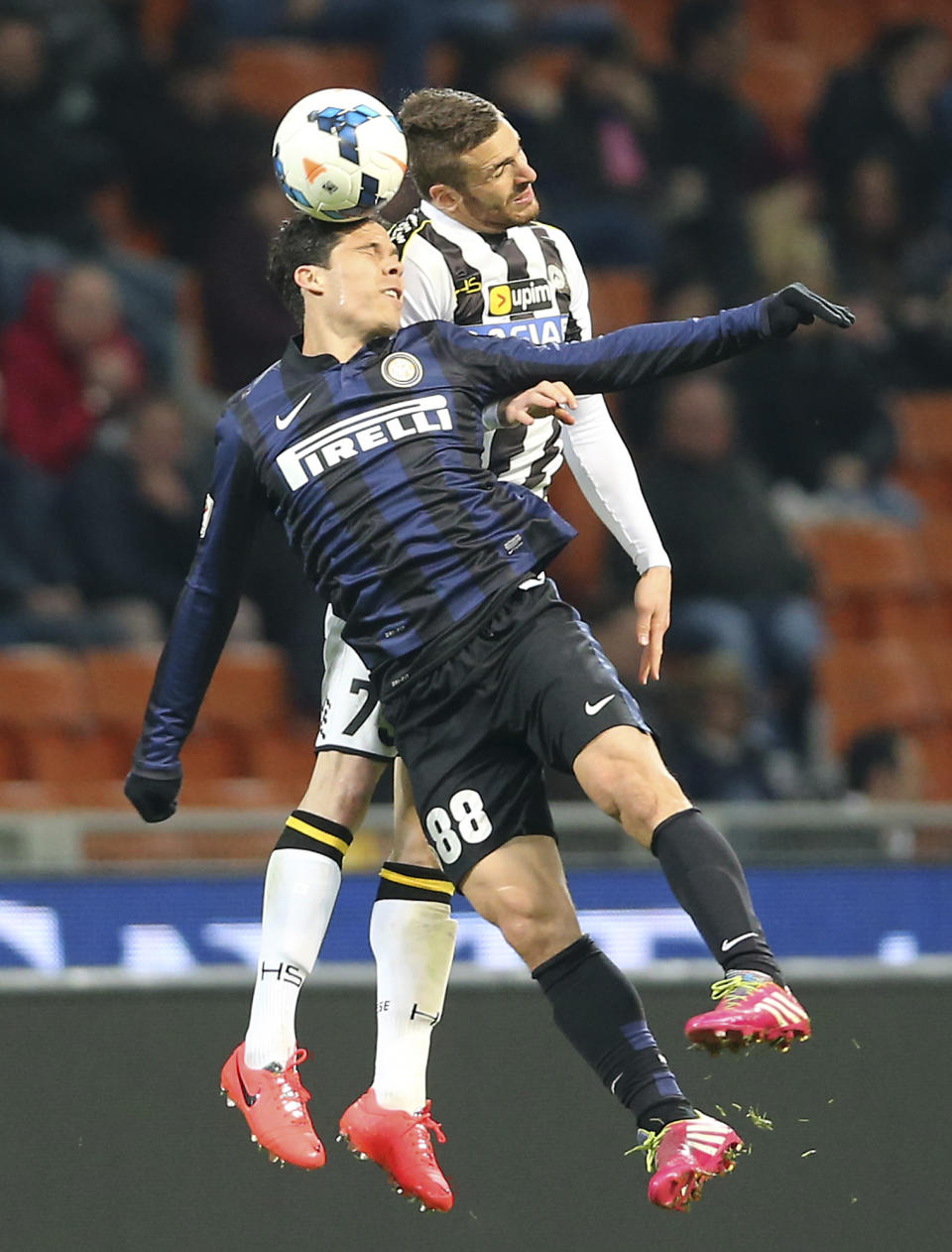 Inter Milan Brazilian midfielder Anderson Hernanes, left, jumps for the ball with Udinese defender Silvan Widmer, of Switzerland, during the Serie A soccer match between Inter Milan and Udinese at the San Siro stadium in Milan, Italy, Thursday, March 27, 2014. (AP Photo/Antonio Calanni)