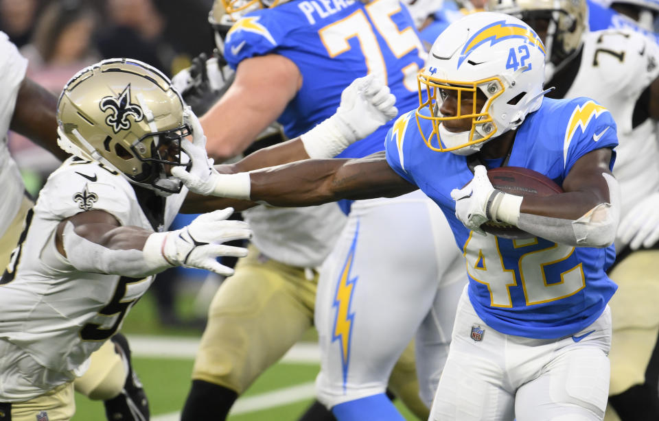 Aug 20, 2023; Inglewood, California, USA; Los Angeles Chargers running back Elijah Dotson (42) stiff arms New Orleans Saints linebacker Anfernee Orji (58) during the third quarter at SoFi Stadium. Mandatory Credit: Robert Hanashiro-USA TODAY Sports