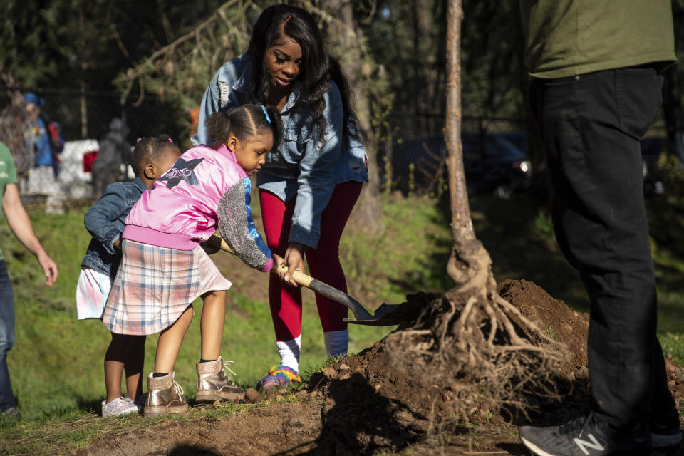 Dozens gathered at Nadaka Nature Park in Gresham, Ore., Saturday morning, March 16, 2024, to hold a tree planting event in memory of those who died during the heatwave of 2021. Multiple trees were planted across the Multnomah County in memory of each life that was lost. Family members and friends of those who passed participated in the event. (Mark Graves/The Oregonian via AP)