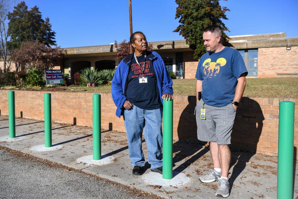 Robert Fletcher (left) and Eric Scott - custodians, coworkers and friends - chat about their jobs outside Cedar Bluff Middle School.