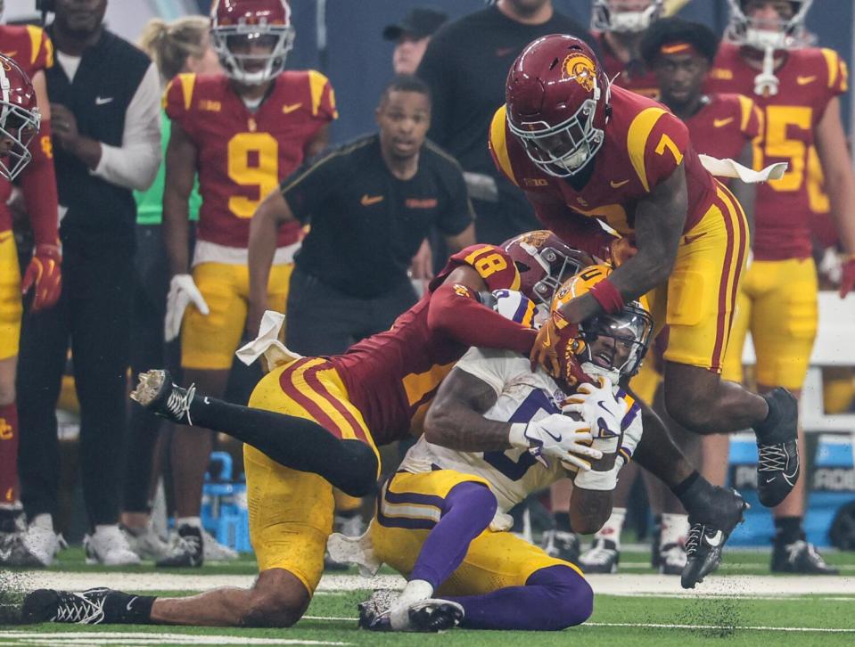 LSU receiver Shelton Sampson Jr. (6) is tackled by USC safety Kamari Ramsey (7) and linebacker Eric Gentry Sunday.