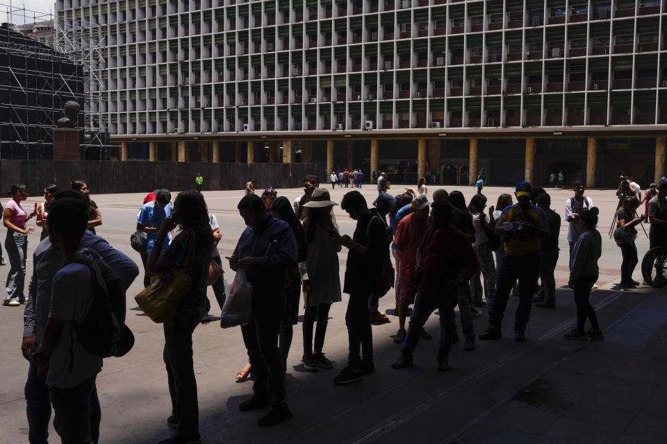 People wait in line to register to vote in the upcoming presidential election in Caracas, Venezuela, Tuesday, April 16, 2024. Voters go to the polls on July 28th. (AP Photo/Ariana Cubillos)