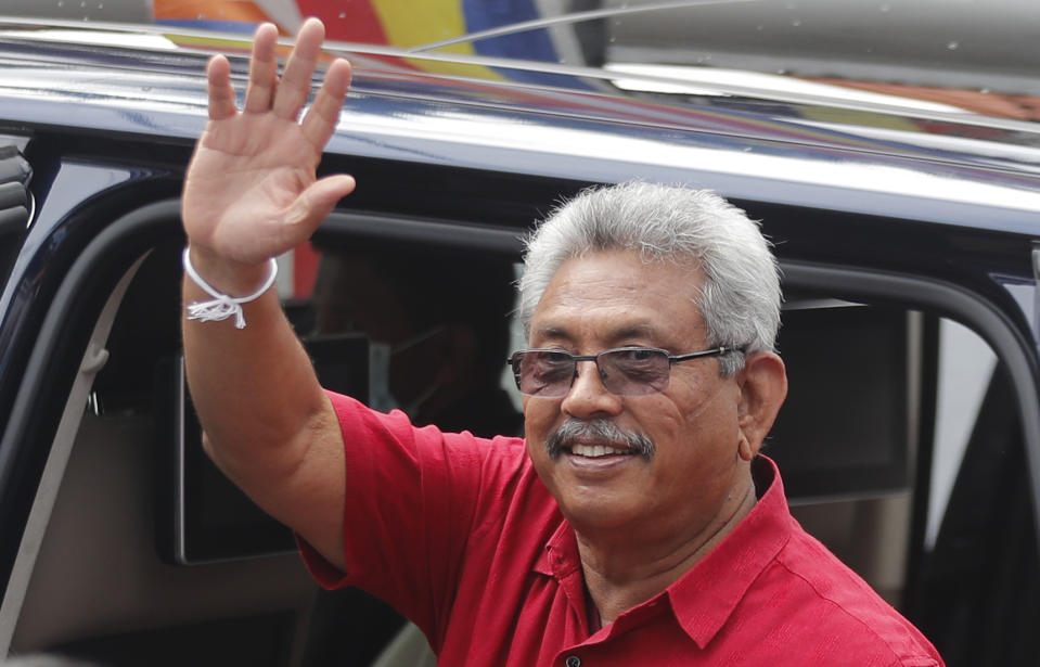 Sri Lankan President Gotabaya Rajapaksa waves as he leaves after casting his vote, outside a polling station in Colombo, Sri Lanka, Wednesday, Aug. 5, 2020. Sri Lankans started voting Wednesday to elect a new Parliament that is expected to give strong support to the powerful and popular Rajapaksa brothers. (AP Photo/Eranga Jayawardena)