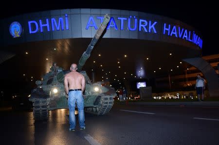 A man stands in front of a Turkish army tank at Ataturk airport in Istanbul, Turkey July 16, 2016. REUTERS/IHLAS News Agency