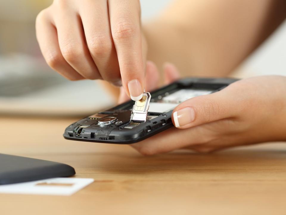 A woman putting a SIM card in her phone