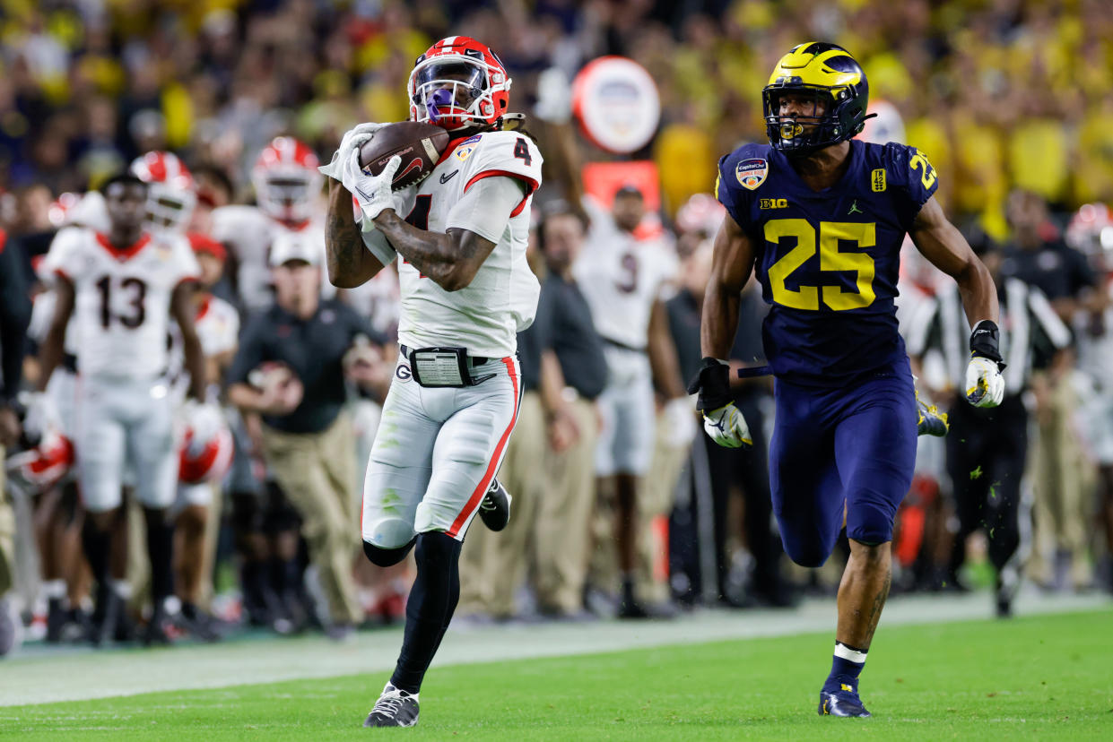 MIAMI GARDENS, FL - DECEMBER 31: Georgia Bulldogs running back James Cook (4) catches a pass while Michigan Wolverines linebacker Junior Colson (25) defends during the Capital One Orange Bowl game between the Georgia Bulldogs and the Michigan Wolverines on December 31, 2021 at Hard Rock Stadium in Miami Gardens, Fl.  (Photo by David Rosenblum/Icon Sportswire via Getty Images)