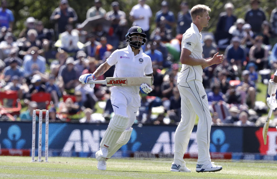 India's Virat Kohl, left, runs around New Zealand's Kyle Jamieson while batting during play on day one of the second cricket test between New Zealand and India at Hagley Oval in Christchurch, New Zealand, Saturday, Feb. 29, 2020. (AP Photo/Mark Baker)