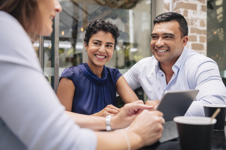 A couple smiling and talking with an advisor.