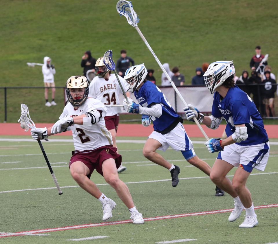 Crew Davis from Iona Prep moves the ball in front of Bronxville defenders during their boys lacrosse game at Iona Prep in New Rochelle, April 5, 2024. Iona Prep beat Bronxville, 14-7.