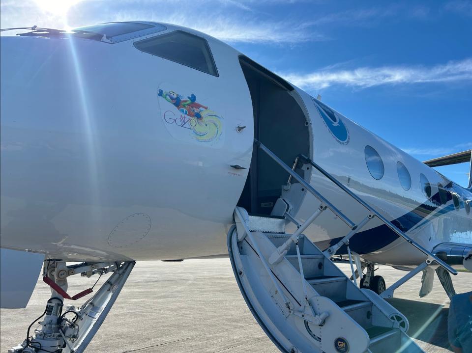 a large white jet sits on a tarmac under a blue sky