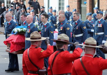 Honour guards salute as the casket of Warrant Officer Patrice Vincent is brought into the church in Longueuil, Quebec November 1, 2014. REUTERS/Christinne Muschi