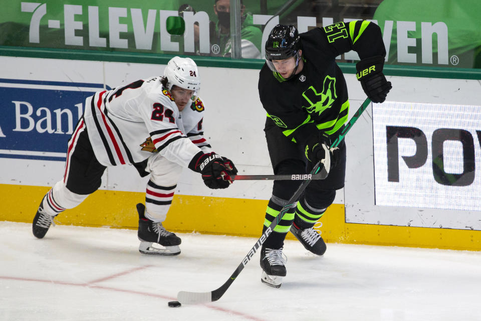 Dallas Stars defenseman Mark Pysyk (13) skates with the puck as Chicago Blackhawks center Pius Suter (24) defends during the first period of an NHL hockey game, Sunday, Feb. 7, 2021, in Dallas. (AP Photo/Sam Hodde)