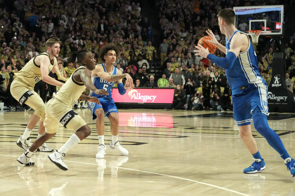 Duke's Tyrese Proctor (5) passes the ball out of bounds past Kyle Filipowski, left, in the final seconds of the second half of an NCAA college basketball game against Wake Forest in Winston-Salem, N.C., Saturday, Feb. 24, 2024. (AP Photo/Chuck Burton)