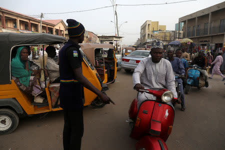 A policeman controls the traffic a day after the postponement of the presidential election in Kano, Nigeria February 17, 2019. REUTERS/Luc Gnago