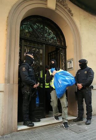 Spanish police carry bags containing evidence from an apartment building during a sweeping operation at some 12 locations against suspected Islamist militants in which eight people were arrested in Barcelona, Spain, April 25, 2017. REUTERS/Albert Gea