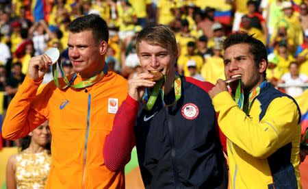 2016 Rio Olympics - Cycling BMX - Victory Ceremony - Men's BMX Victory Ceremony - Olympic BMX Centre - Rio de Janeiro, Brazil - 19/08/2016. Silver medalist Jelle van Gorkom (NED) of Netherlands, gold medalist Connor Fields (USA) of USA and Carlos Ramirez (COL) of Colombia pose with their medals on the podium. REUTERS/Paul Hanna