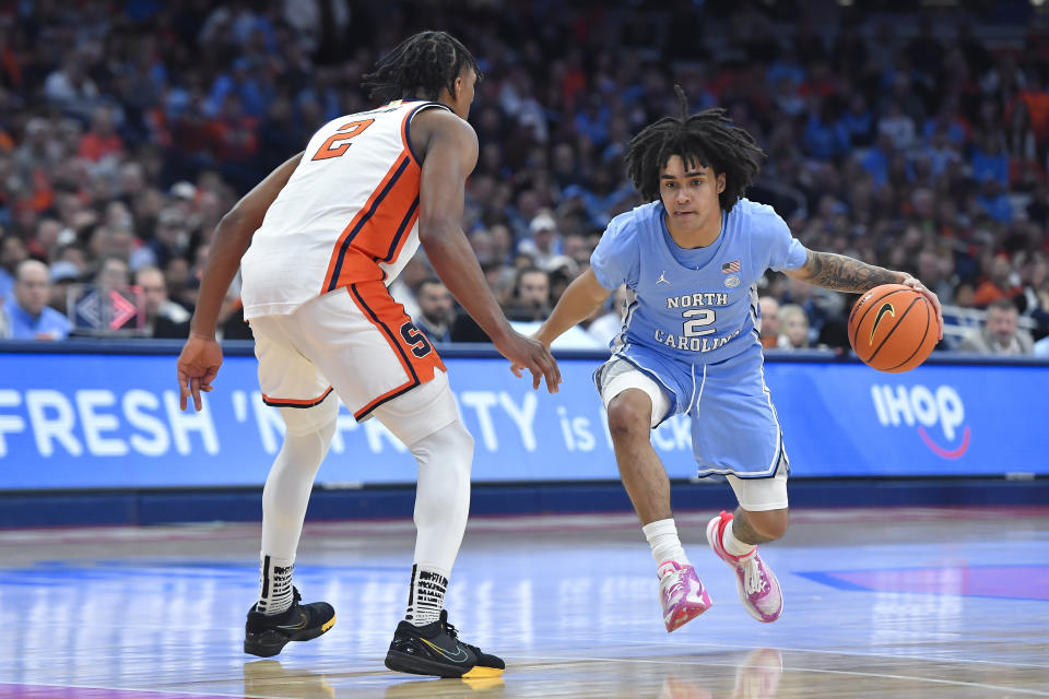 North Carolina guard Elliot Cadeau, right, is defended by Syracuse guard J.J. Starling during the first half of an NCAA college basketball game in Syracuse, N.Y., Tuesday, Feb. 13, 2024. (AP Photo/Adrian Kraus)