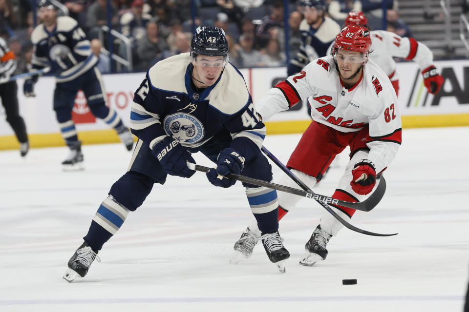 Columbus Blue Jackets' Alexandre Texier, left, carries the puck across the blue line as Carolina Hurricanes' Jesperi Kotkaniemi defends during the second period of an NHL hockey game Tuesday, April 16, 2024, in Columbus, Ohio. (AP Photo/Jay LaPrete)