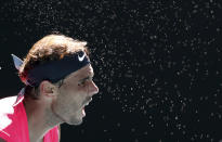 Spain's Rafael Nadal serves to compatriot Pablo Carreno Busta during their third round singles match at the Australian Open tennis championship in Melbourne, Australia, Saturday, Jan. 25, 2020. (AP Photo/Dita Alangkara)