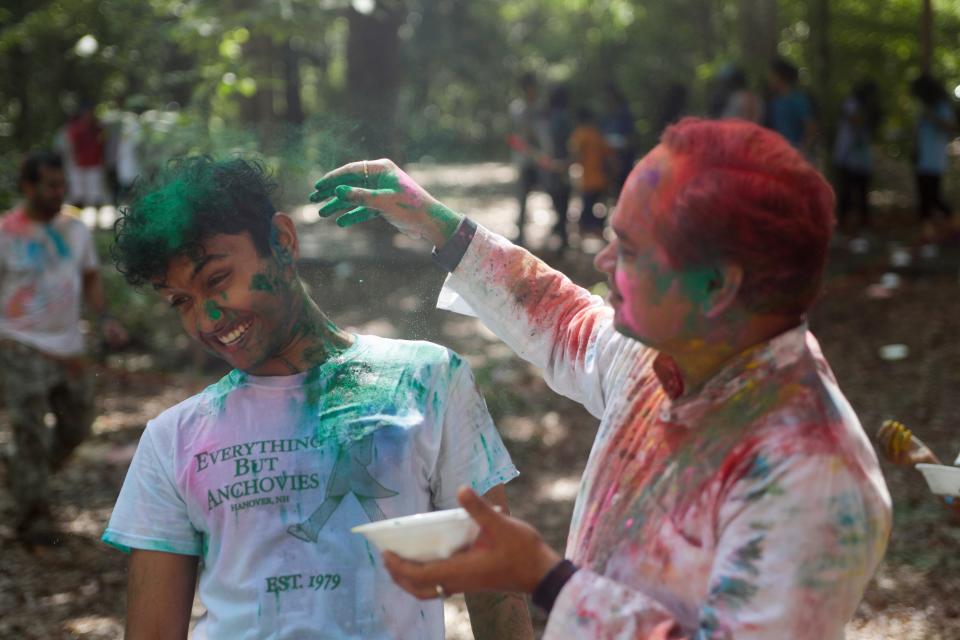 Pushpendra Srivastava throws green color in the hair of his son Apurva Srivastava, 16, during a Holi celebration organized by the India Association of Tallahassee at A.J. Henry Park Sunday, March 24, 2019. 