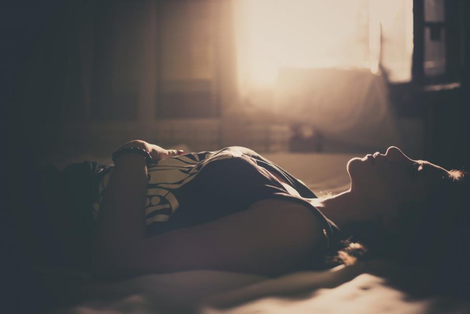 Woman lying in darkness in bed