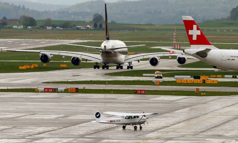 FILE PHOTO: A private Cessna rolls in front of an Airbus airplane of Singapore Airlines and an Airbus of Swiss airlines at Zurich airport