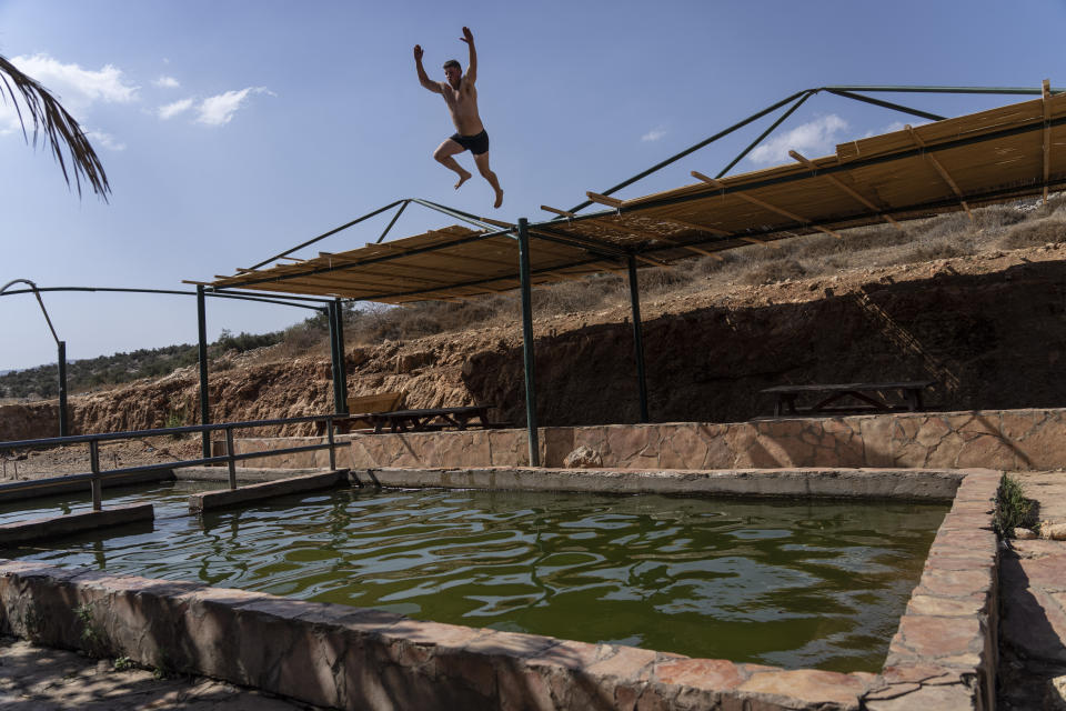 FILE - An off-duty Israeli soldier jumps into Kfir spring, near the West Bank town of Nablus, Sunday, Oct. 16, 2022. The tourism minister of Israel's new hardline government on Sunday, Jan. 1, 2023 promised to invest in developing the West Bank, calling the occupied area "our local Tuscany." (AP Photo/Tsafrir Abayov, File)