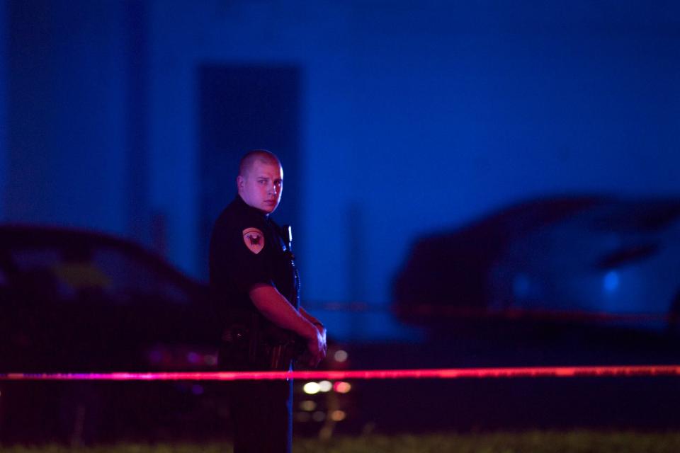 In this Sept. 7, 2016 photo, a police officer guards the scene after a police officer fatally shot a man who was suspected of stealing a semi-automatic pistol from a gun store in Wyoming, Mich., in the suburbs of Grand Rapids. Community leaders in Grand Rapids say the police can only do so much. They're looking for more proactive measures as opposed to reactive ones.<span class="copyright">Tom Brenner—Grand Rapids Press/AP</span>