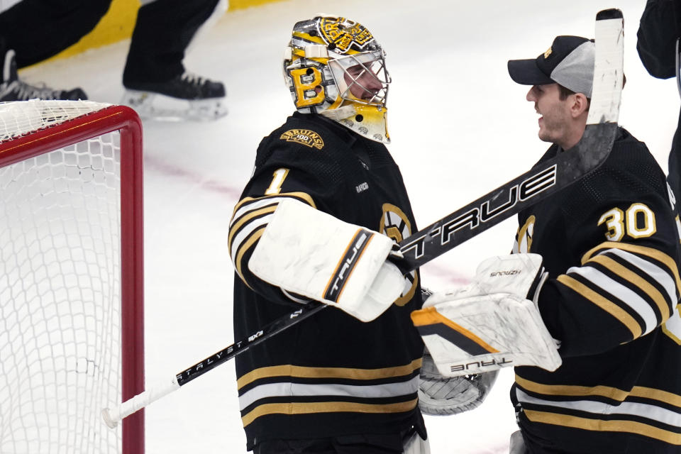 Boston Bruins goaltender Jeremy Swayman (1) is congratulated by goalie Brandon Bussi after shutting out the New Jersey Devils 3-0 in an NHL hockey game, Monday, Jan. 15, 2024, in Boston. (AP Photo/Charles Krupa)