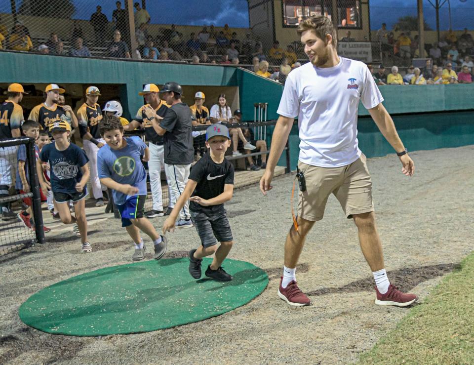 Team operations intern Mickey Babb leads kids onto the field to run the bases during a 2021 game at Pat Thomas Stadium-Buddy Lowe Field in Leesburg. A new group of interns are on board for the 2022 season, ready to help add to the ballpark experience for fans of all ages.