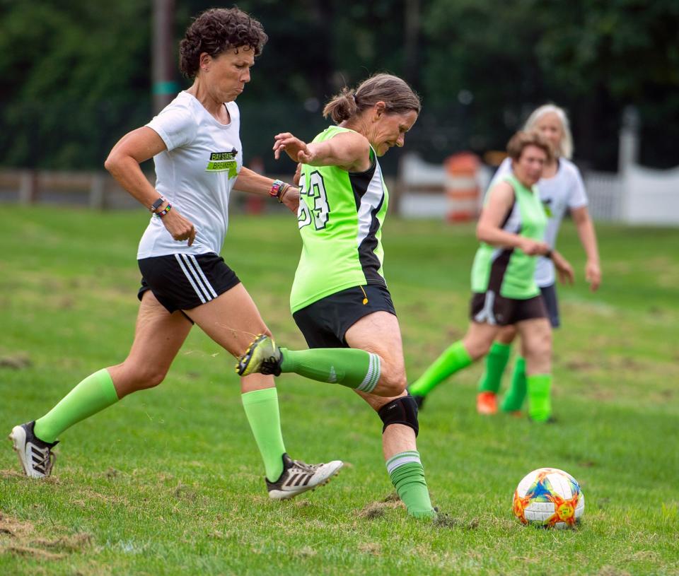 Deb Keohane, of Bedford, center, with Mary Ann Vachweill, of Waltham defending, left, at a Bay State Breakers practice at the Brophy School in Framingham, July 21, 2023.