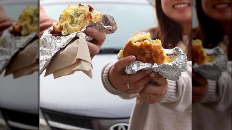 People holding breakfast sandwiches