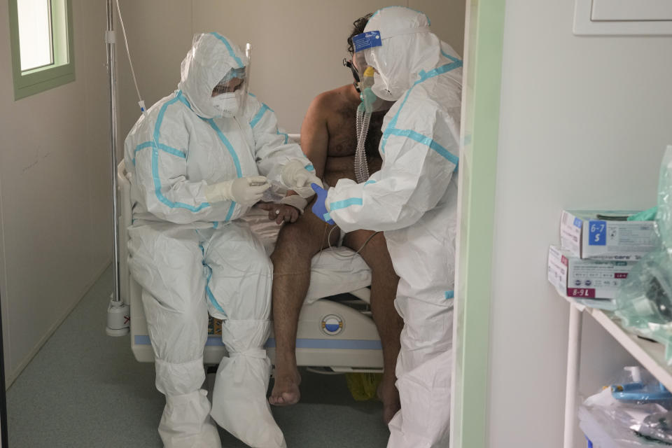 Medical staff attend to a patient at the COVID-19 ICU unit of the Marius Nasta National Pneumology Institute in Bucharest, Romania, Thursday, Sept. 23, 2021. Daily new coronavirus infections in Romania, a country of 19 million, have grown exponentially over the last month, while vaccine uptake has declined to worrying lows. Government data shows that 91.5% of COVID-19 deaths in Romania between Sept. 18-23 were people who had not been vaccinated. (AP Photo/Vadim Ghirda)