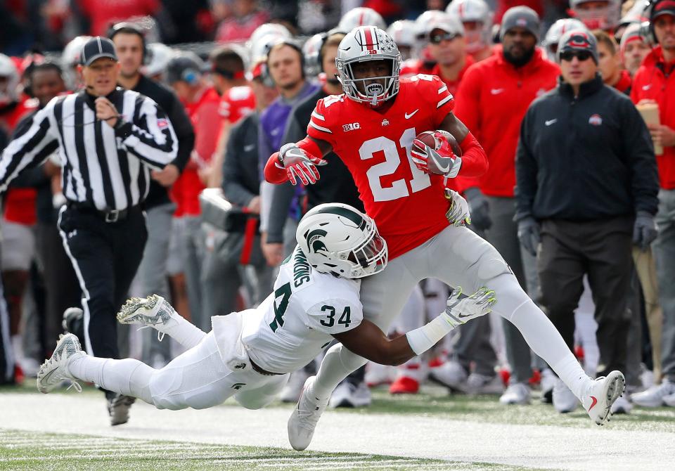 Ohio State Buckeyes wide receiver Parris Campbell (21) is tackled by Michigan State Spartans linebacker Antjuan Simmons (34) during the first quarter at Ohio Stadium.