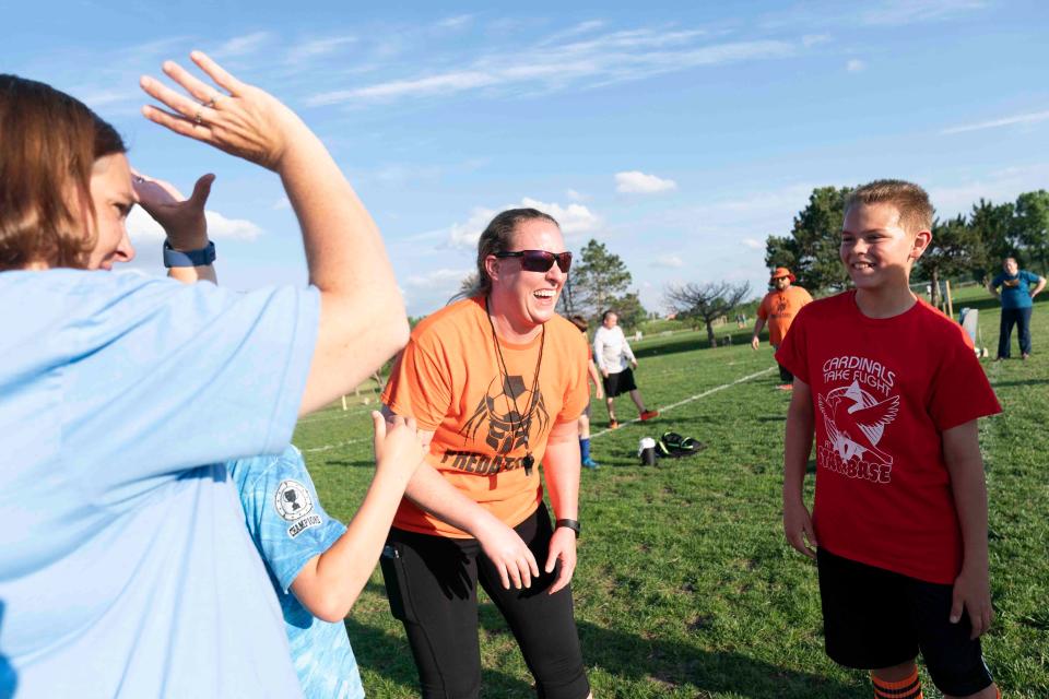 At right, Bryson Hale, 10, gets, from left, his mother Sara, brother Ben and soccer coach Bailey Mushock, to laugh as they joke about body odor through sign language during a break in play Thursday at Sunflower Sports Association. Mushock is fluent in ASL and communicates with Bryson on and off the field.