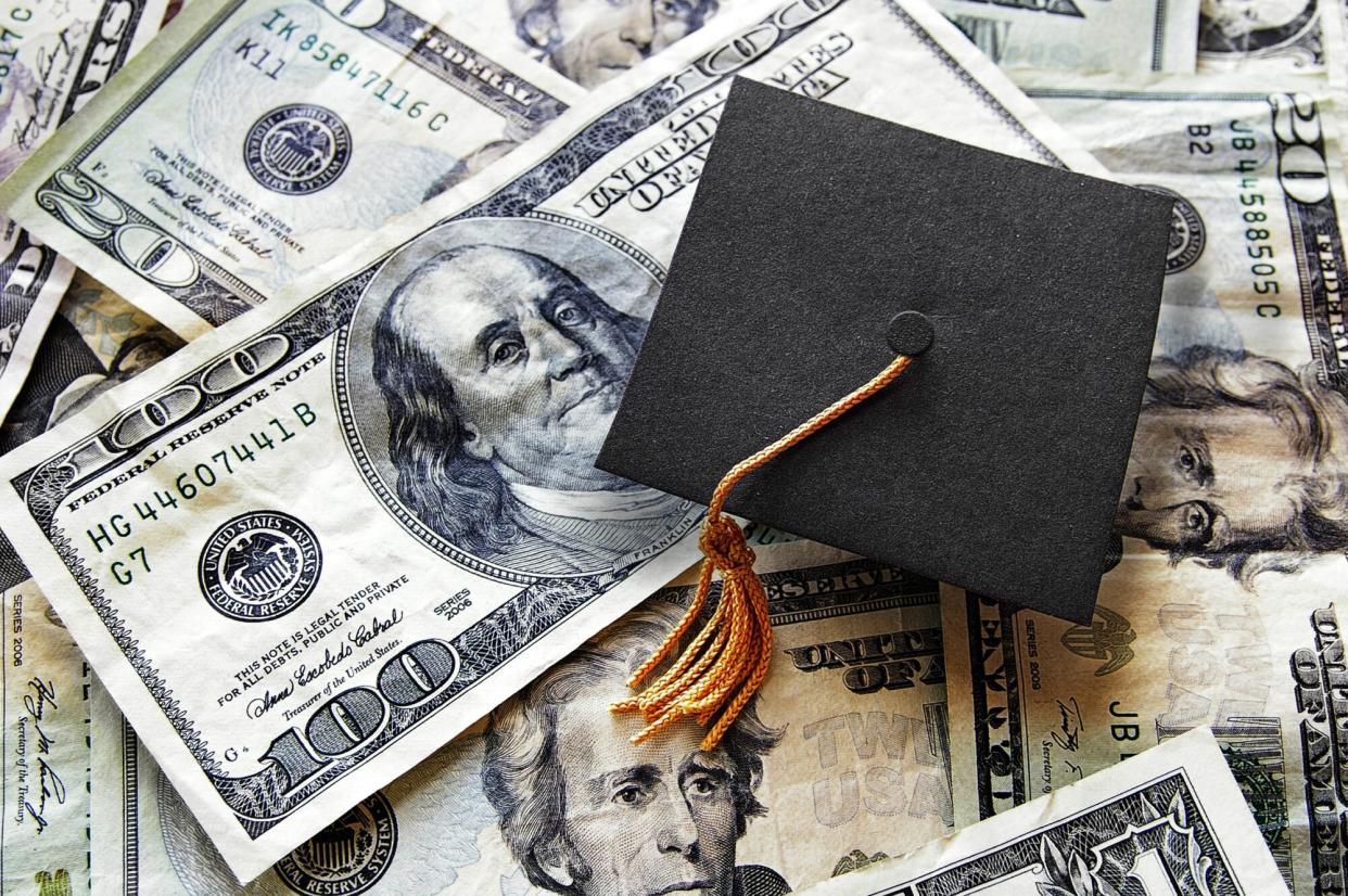 An image of a graduation cap on a pile of money.