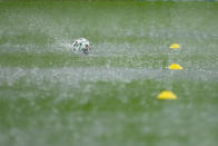 A ball falls on the wet pitch during a heavy rainfall before Austria's training session at the National Arena stadium in Bucharest, Romania, Saturday, June 12, 2021, the day before their first match against North Macedonia. (AP Photo/Vadim Ghirda)