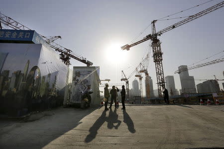 Workers chat outside a construction site in Beijing's central business district, in this December 29, 2014 file photo. REUTERS/Jason Lee/Files