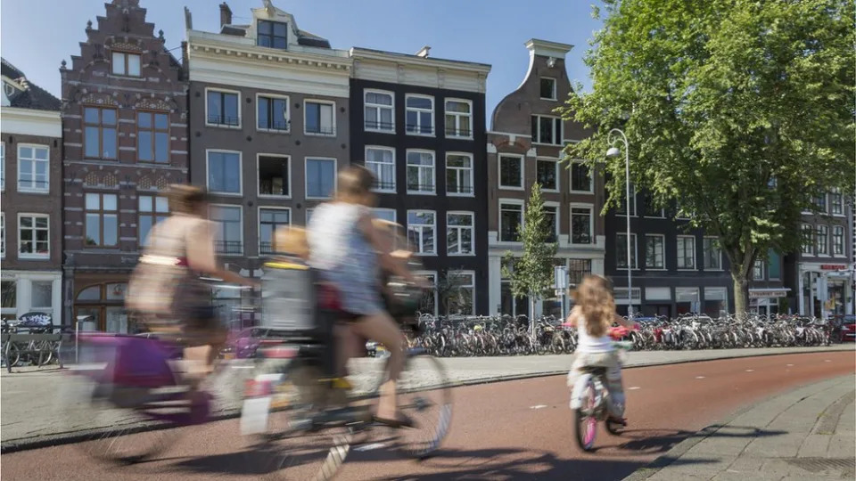 Adultos y nios andando en bicicleta por msterdam.