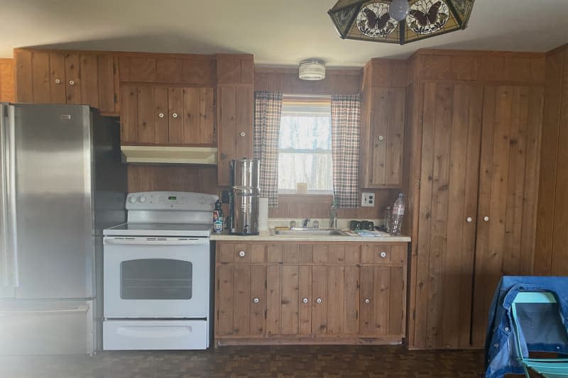 Dark wooden cabinets in rustic kitchen before renovation.