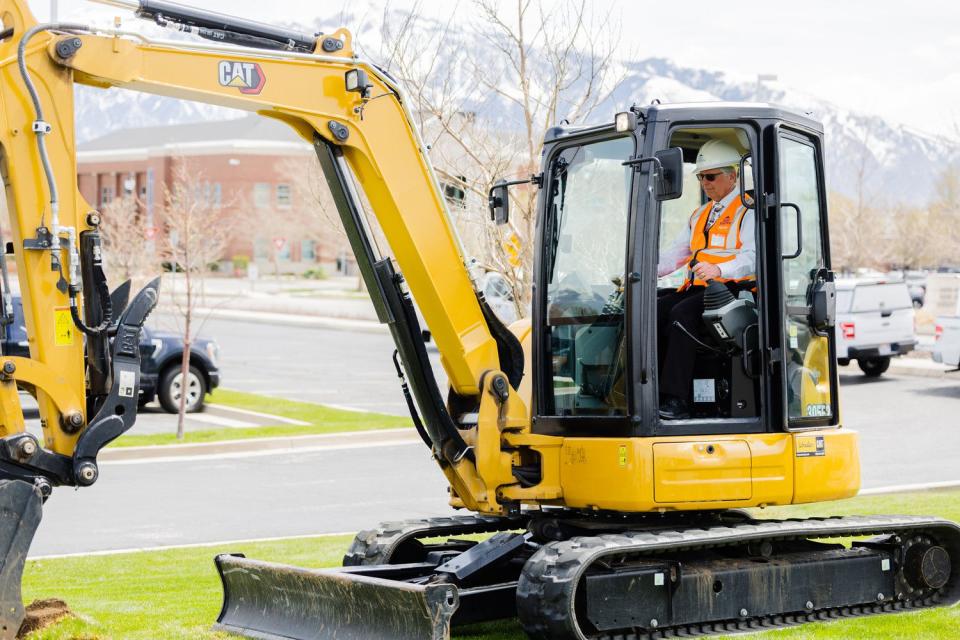 West Jordan Mayor Dick Burton operates an excavator during a press conference announcing grants for the conversion of grass fields at the West Jordan City Hall on Thursday.