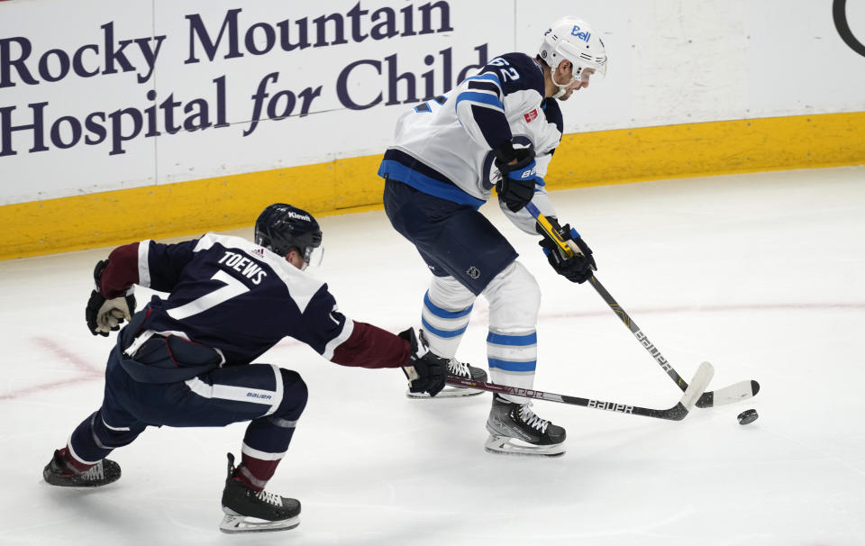 Colorado Avalanche defenseman Devon Toews, left, defends against Winnipeg Jets right wing Nino Niederreiter during the first period of an NHL hockey game Thursday, April 13, 2023, in Denver. (AP Photo/David Zalubowski