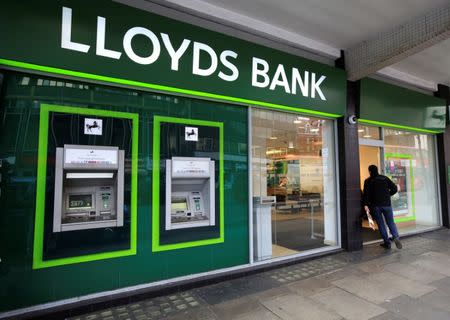 FILE PHOTO: A man enters a Lloyds Bank branch in central London, Britain February 25, 2016. Lloyds Banking Group rewarded investors with a surprise 2 billion pound payout on Thursday, underlying its intent to be the biggest dividend payer among Britain's banks and its recovery after a state bailout. REUTERS/Paul Hackett/File Photo