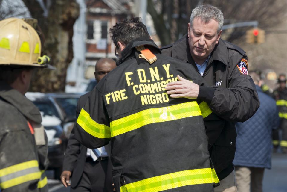 New York Mayor Bill de Blasio embraces New York City Fire Department Commissioner Daniel Nigro after arriving to the site of a home fire in the Midwood neighborhood of Brooklyn, New York