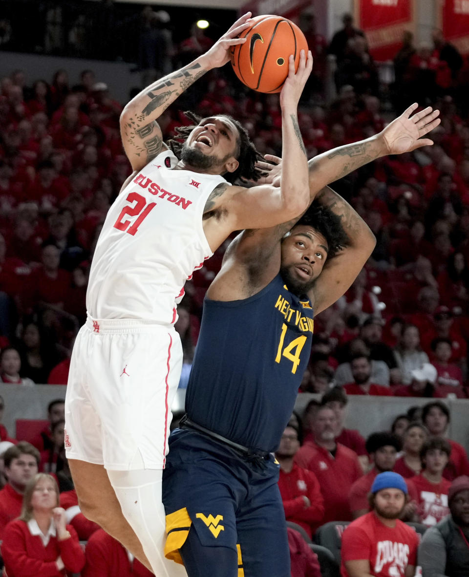 Houston guard Emanuel Sharp (21) shoots as West Virginia guard Seth Wilson (14) defends during the first half of an NCAA college basketball game Saturday Jan. 6, 2024, in Houston. (AP Photo/Eric Christian Smith)