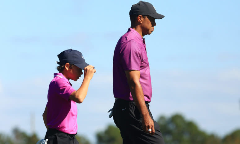 Charlie and Tiger Woods walk together.