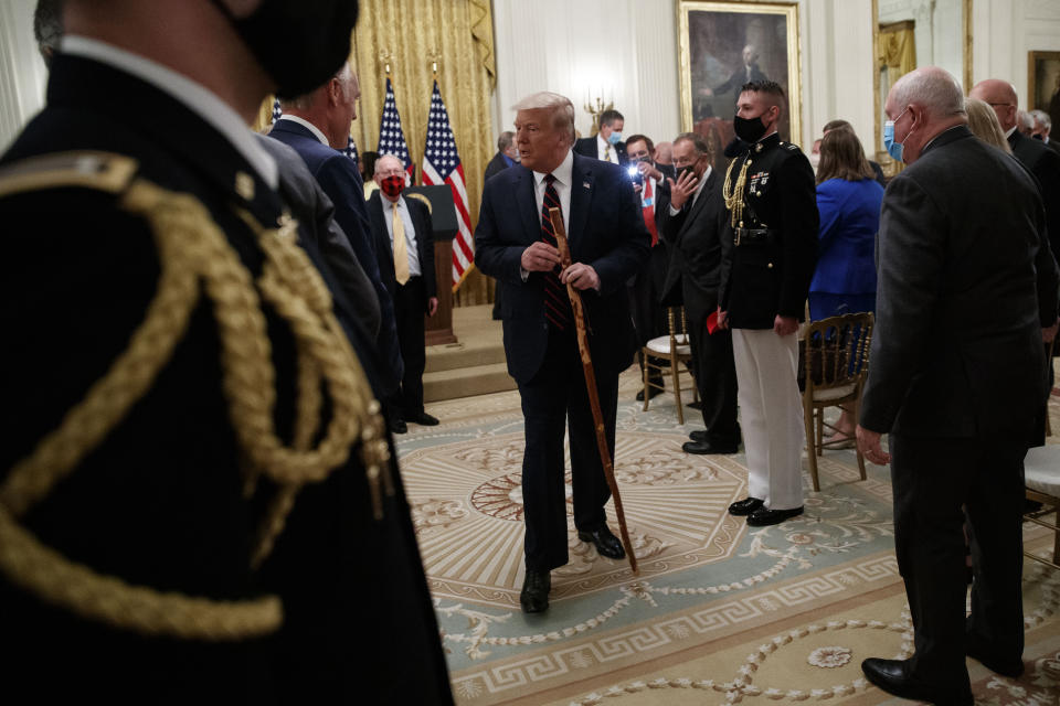 President Donald Trump departs carrying a walking stick given to him by Sen. Lamar Alexander, R-Tenn., after a signing ceremony for H.R. 1957 – "The Great American Outdoors Act," in the East Room of the White House, Tuesday, Aug. 4, 2020, in Washington. (AP Photo/Alex Brandon)