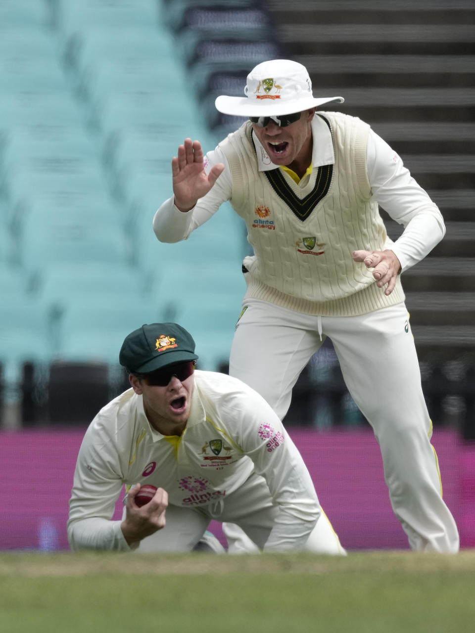 Australia's Steve Smith, bottom, is congratulated by teammate David Warner after believing he has caught out South Africa's Dean Elgar during the fourth day of their cricket test match at the Sydney Cricket Ground in Sydney, Saturday, Jan. 7, 2023. (AP Photo/Rick Rycroft)