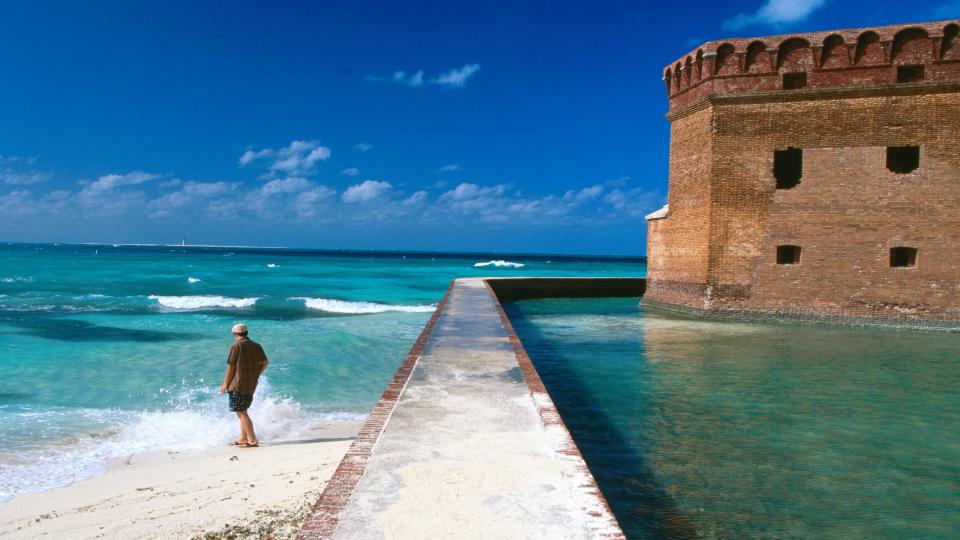 Tourist near moat wall of Fort Jefferson, Garden Key