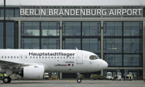 A 'Lufthansa' ariplane is parked in front of Terminal 1 after its arrival at the new Berlin-Brandenburg-Airport 'Willy Brandt' in Berlin, Germany, Saturday, Oct. 31, 2020. Berlin's new airport opens after years of delays and cost overruns. (AP Photo/Michael Sohn)